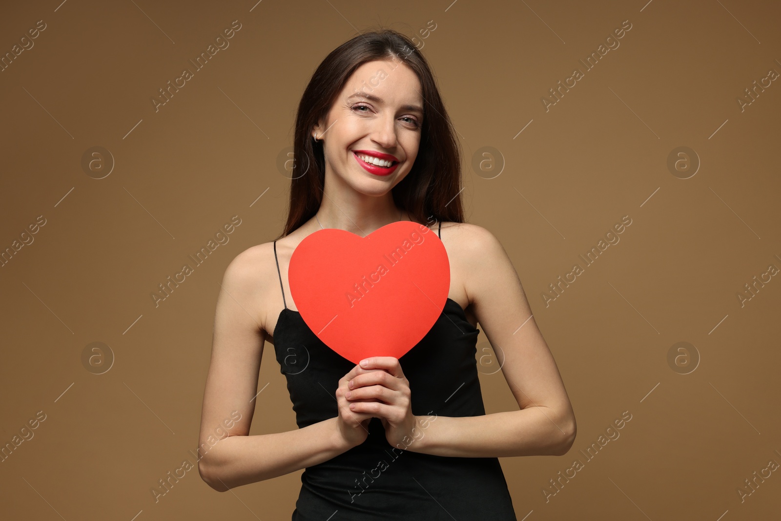 Photo of Happy Valentine's Day. Beautiful woman with paper heart on brown background