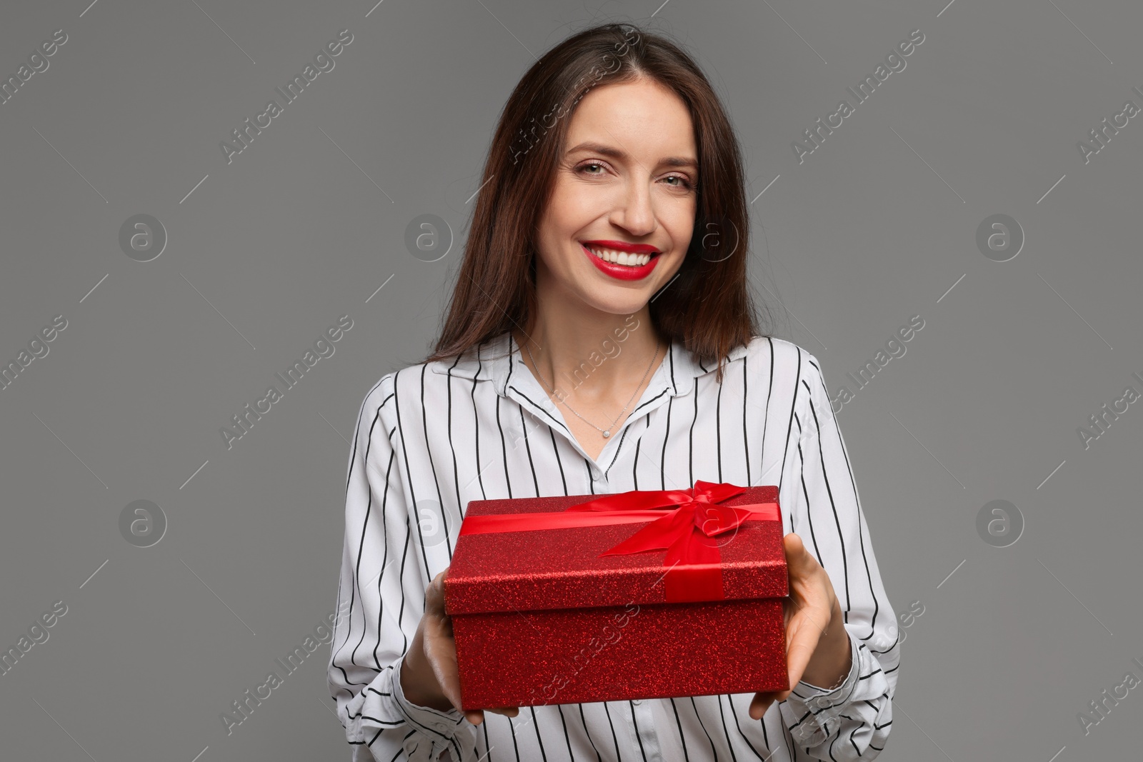 Photo of Happy Valentine's Day. Beautiful woman with gift on grey background