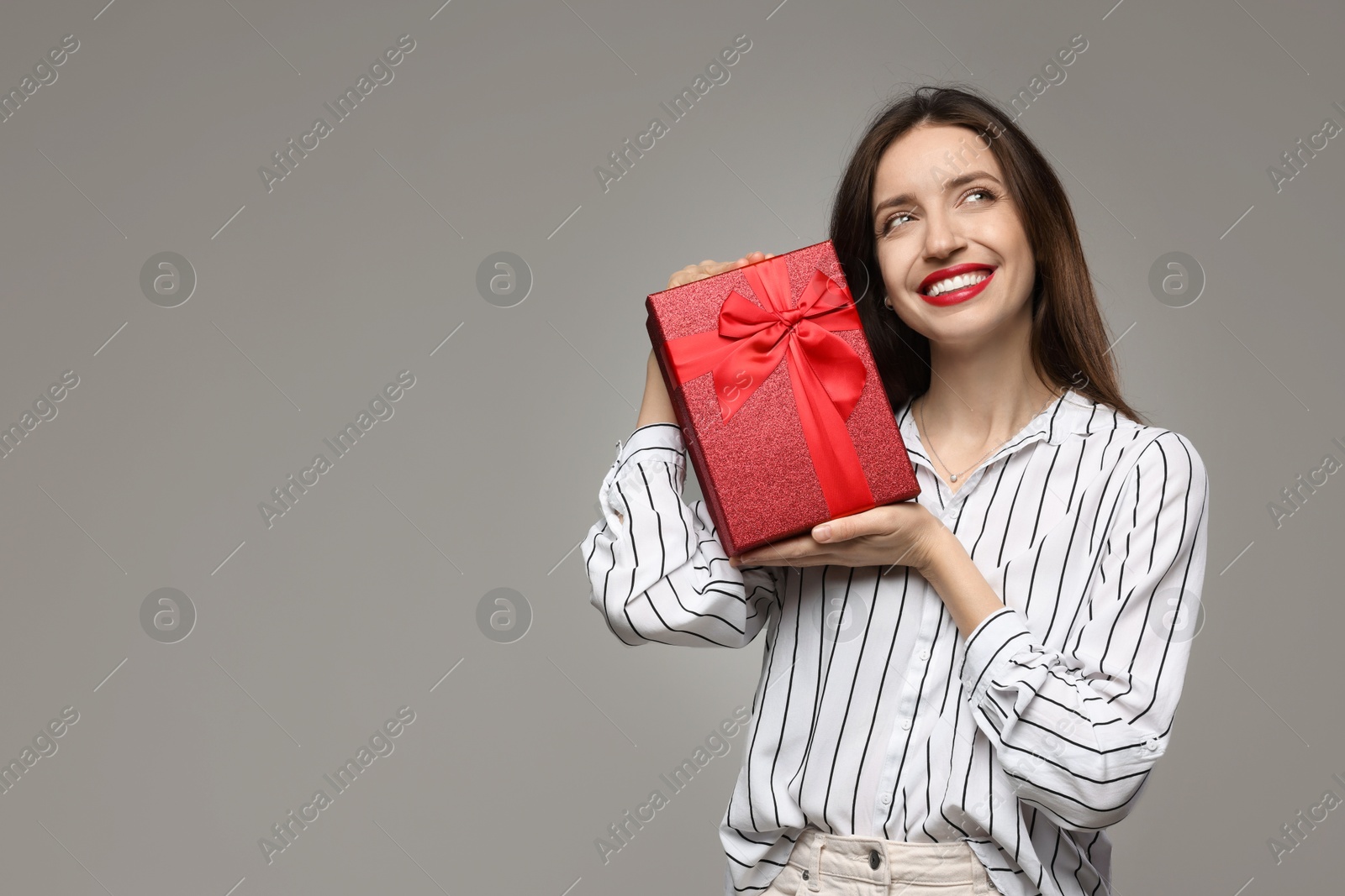 Photo of Happy Valentine's Day. Beautiful woman with gift on grey background. Space for text