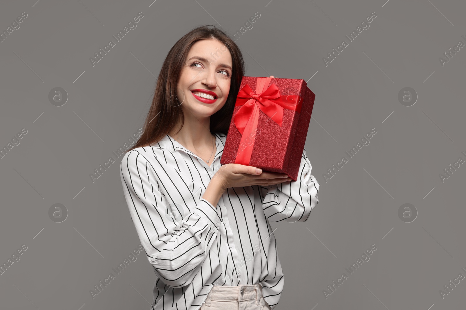 Photo of Happy Valentine's Day. Beautiful woman with gift on grey background