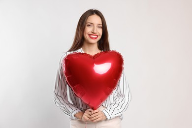 Photo of Happy Valentine's Day. Beautiful woman with heart shaped balloon on white background