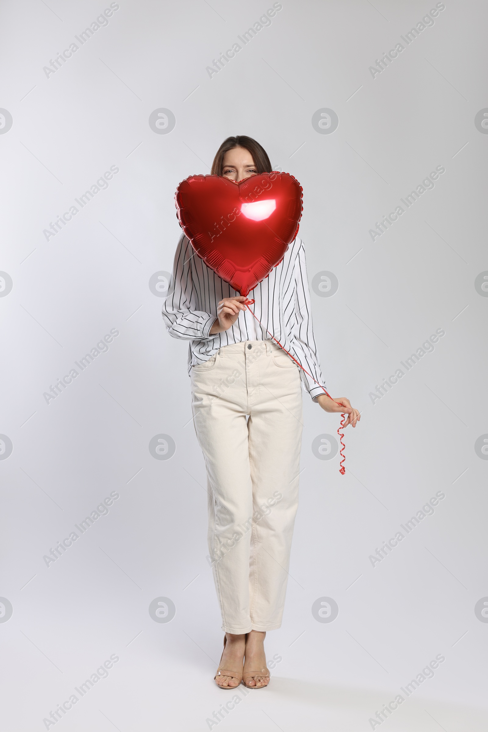 Photo of Happy Valentine's Day. Beautiful woman with heart shaped balloon on white background