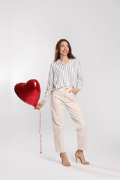 Photo of Happy Valentine's Day. Beautiful woman with heart shaped balloon on white background