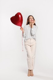 Photo of Happy Valentine's Day. Beautiful woman with heart shaped balloon on white background