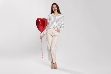 Photo of Happy Valentine's Day. Beautiful woman with heart shaped balloon on white background