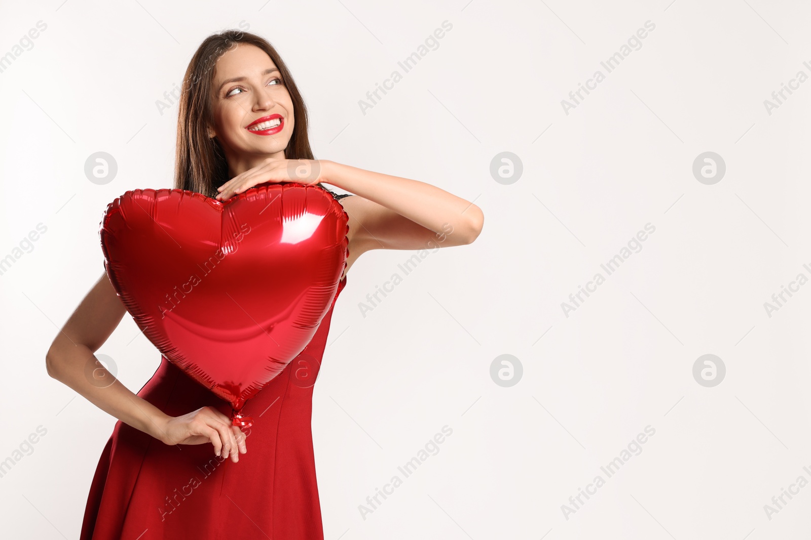 Photo of Happy Valentine's Day. Beautiful woman with heart shaped balloon on white background. Space for text