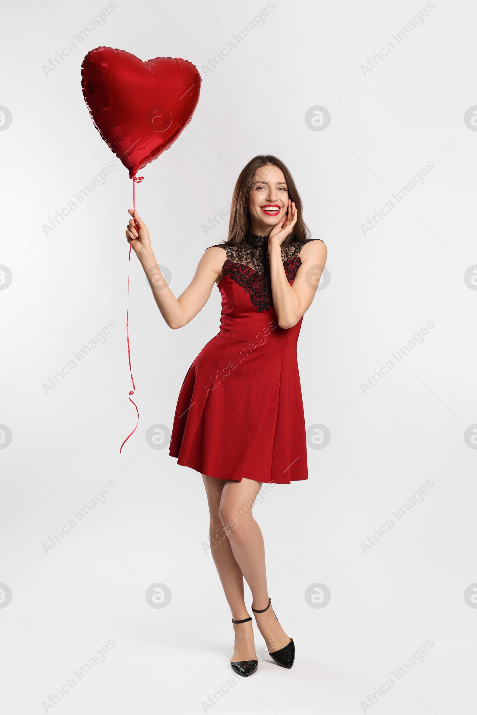 Photo of Happy Valentine's Day. Beautiful woman with heart shaped balloon on white background