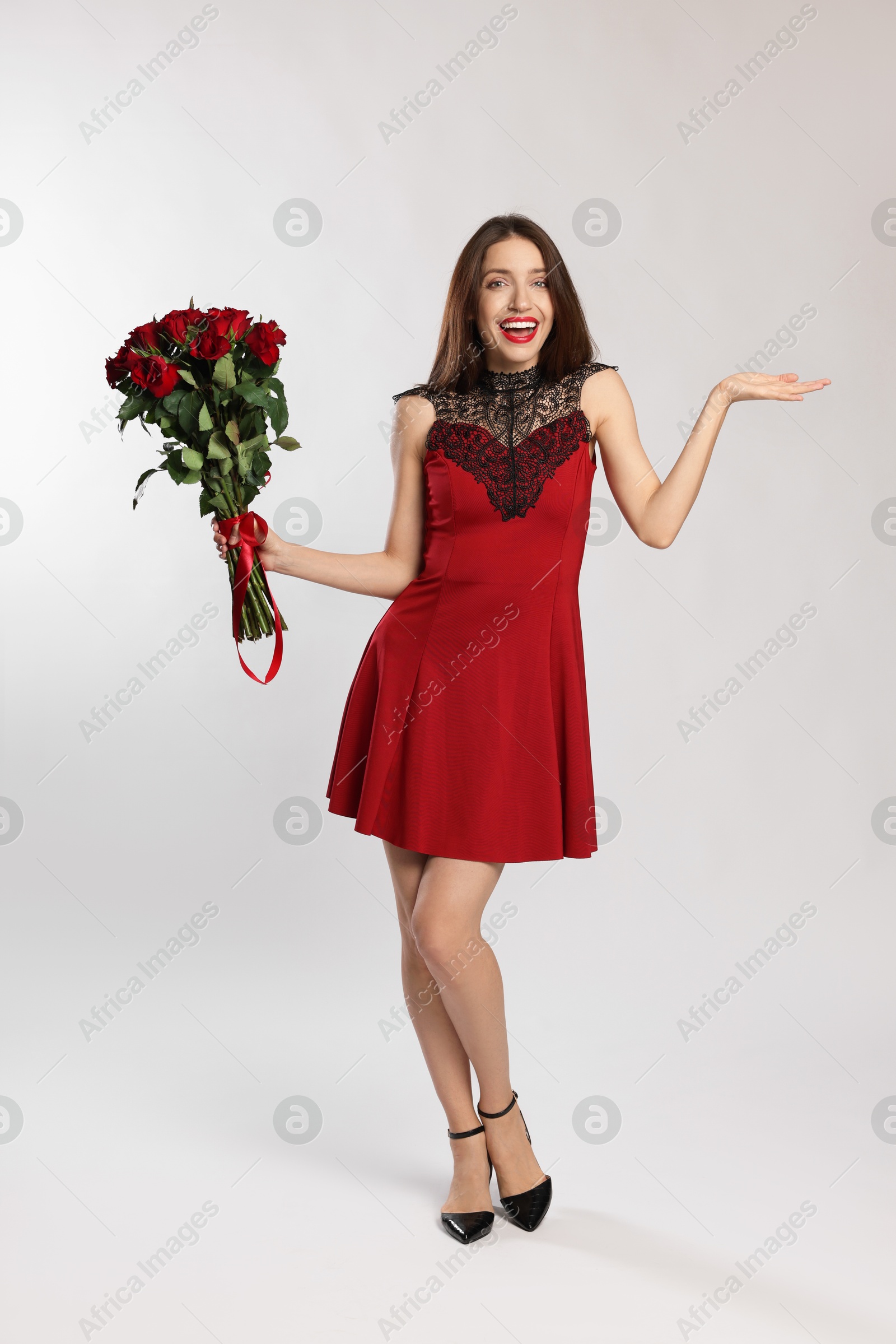 Photo of Happy Valentine's Day. Beautiful woman with bouquet of roses on white background