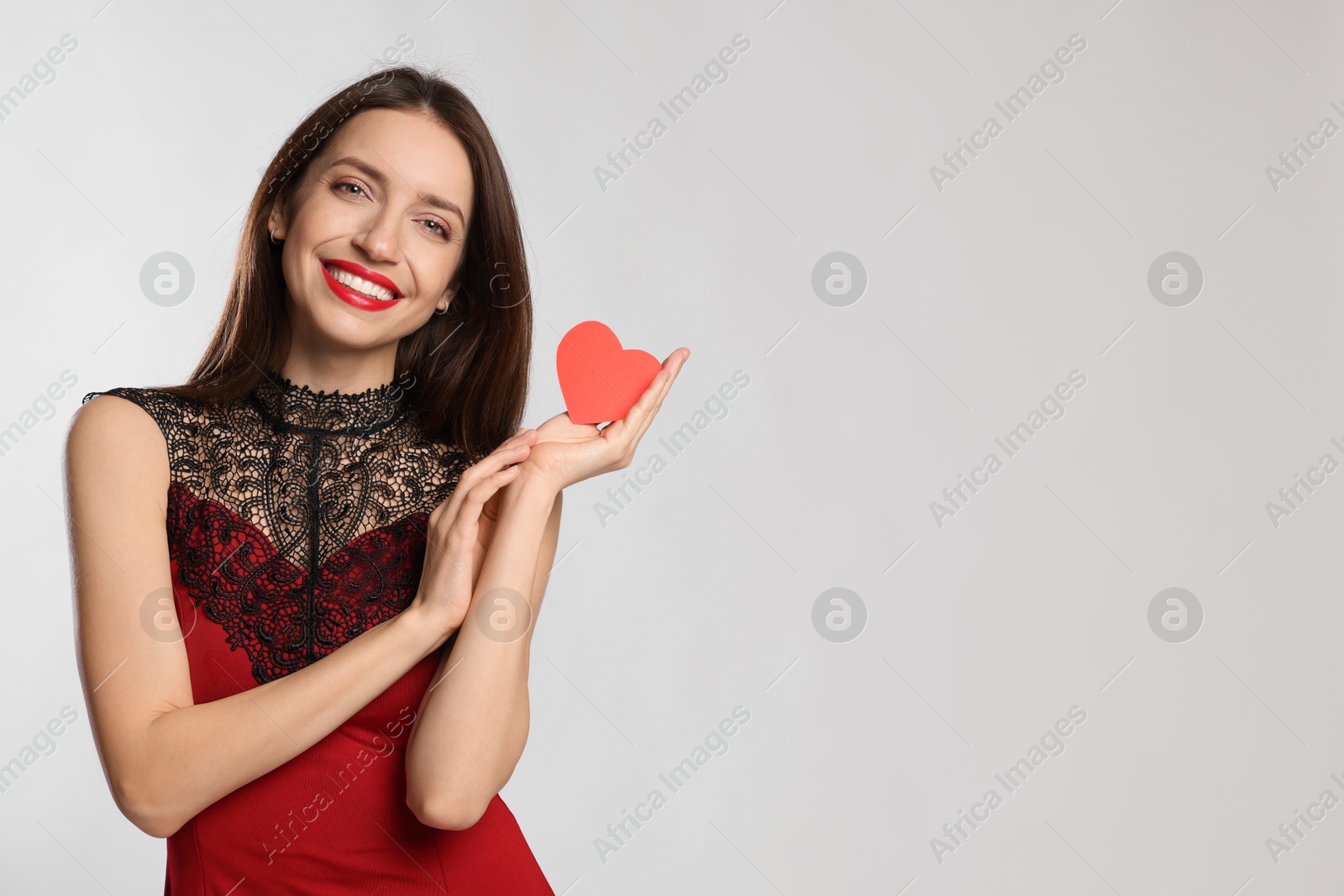 Photo of Happy Valentine's Day. Beautiful woman with paper heart on white background. Space for text