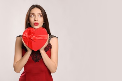 Photo of Happy Valentine's Day. Beautiful woman with heart shaped gift box sending air kiss on white background. Space for text