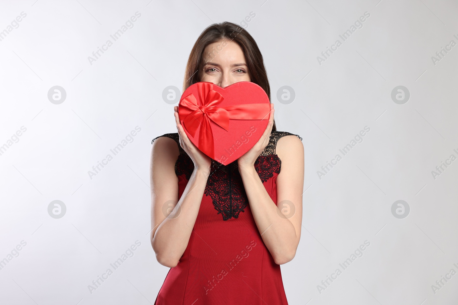 Photo of Happy Valentine's Day. Beautiful woman with heart shaped gift box on white background