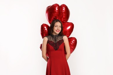 Photo of Happy Valentine's Day. Beautiful woman with heart shaped balloons on white background