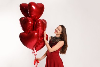 Happy Valentine's Day. Beautiful woman with heart shaped balloons on white background