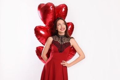 Photo of Happy Valentine's Day. Beautiful woman with heart shaped balloons on white background