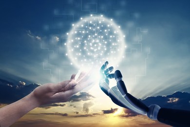 Image of Woman and robot touching data network against sunset sky, closeup of hands. Concept of collaboration between AI and human. Modern technology