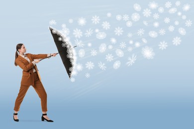 Image of Businesswoman protecting herself from snowstorm with umbrella on light blue gradient background