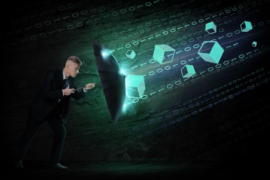 Image of Businessman protecting himself from binary code and digital elements with umbrella in darkness. Cyber security