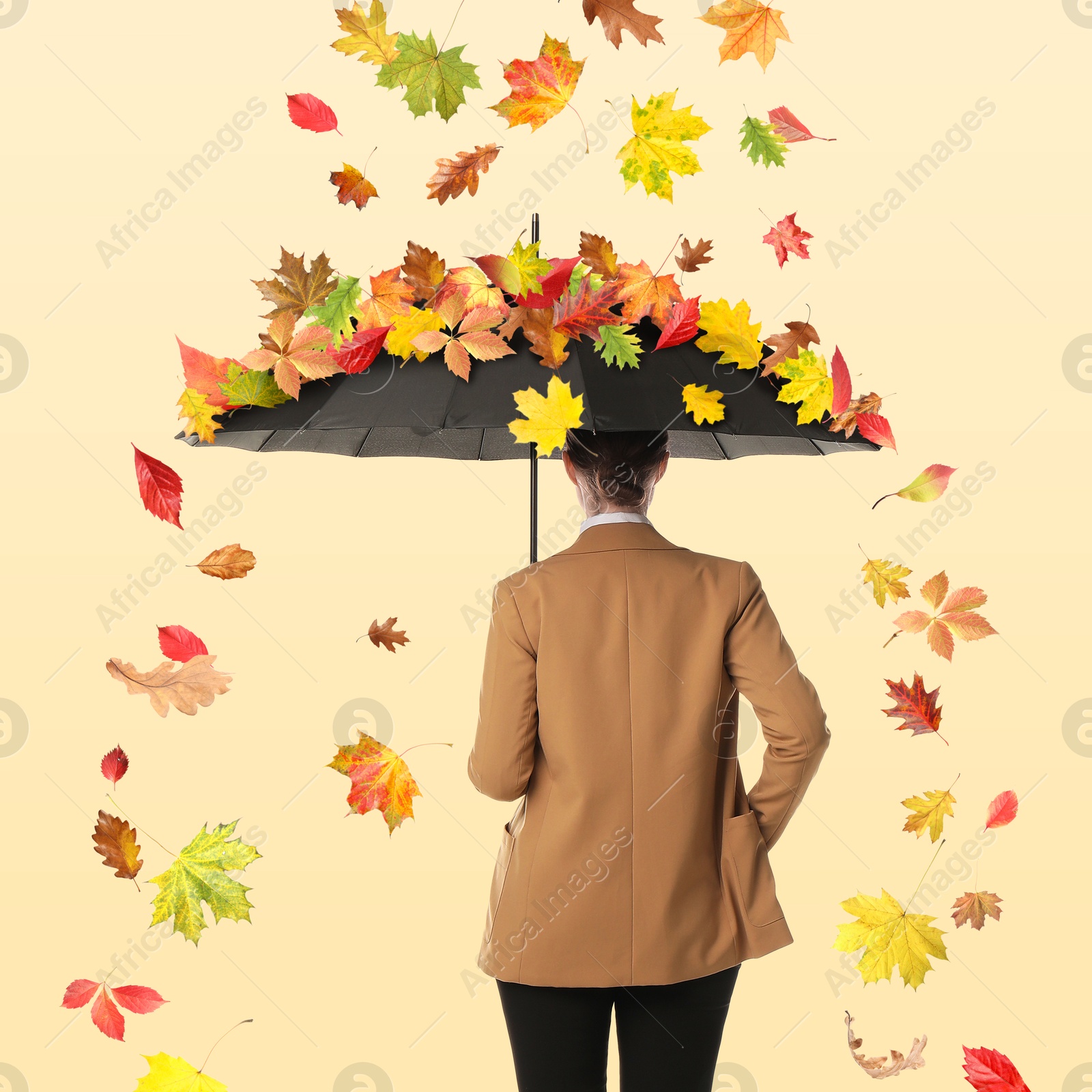 Image of Businesswoman protecting herself from falling leaves with umbrella on beige background