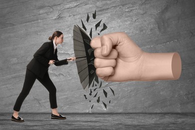 Image of Businesswoman protecting herself from big fist with umbrella on grey textured background