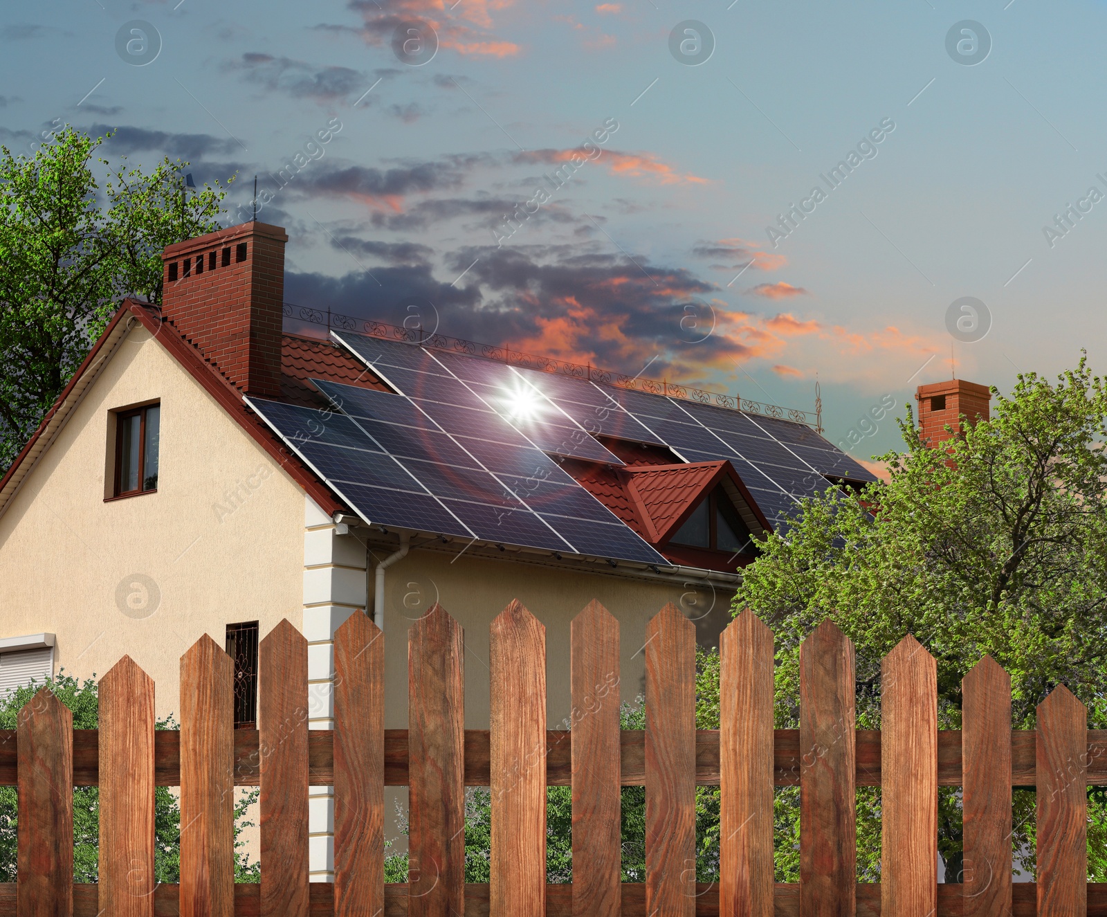 Image of Green energy. House with solar panels on roof at sunset