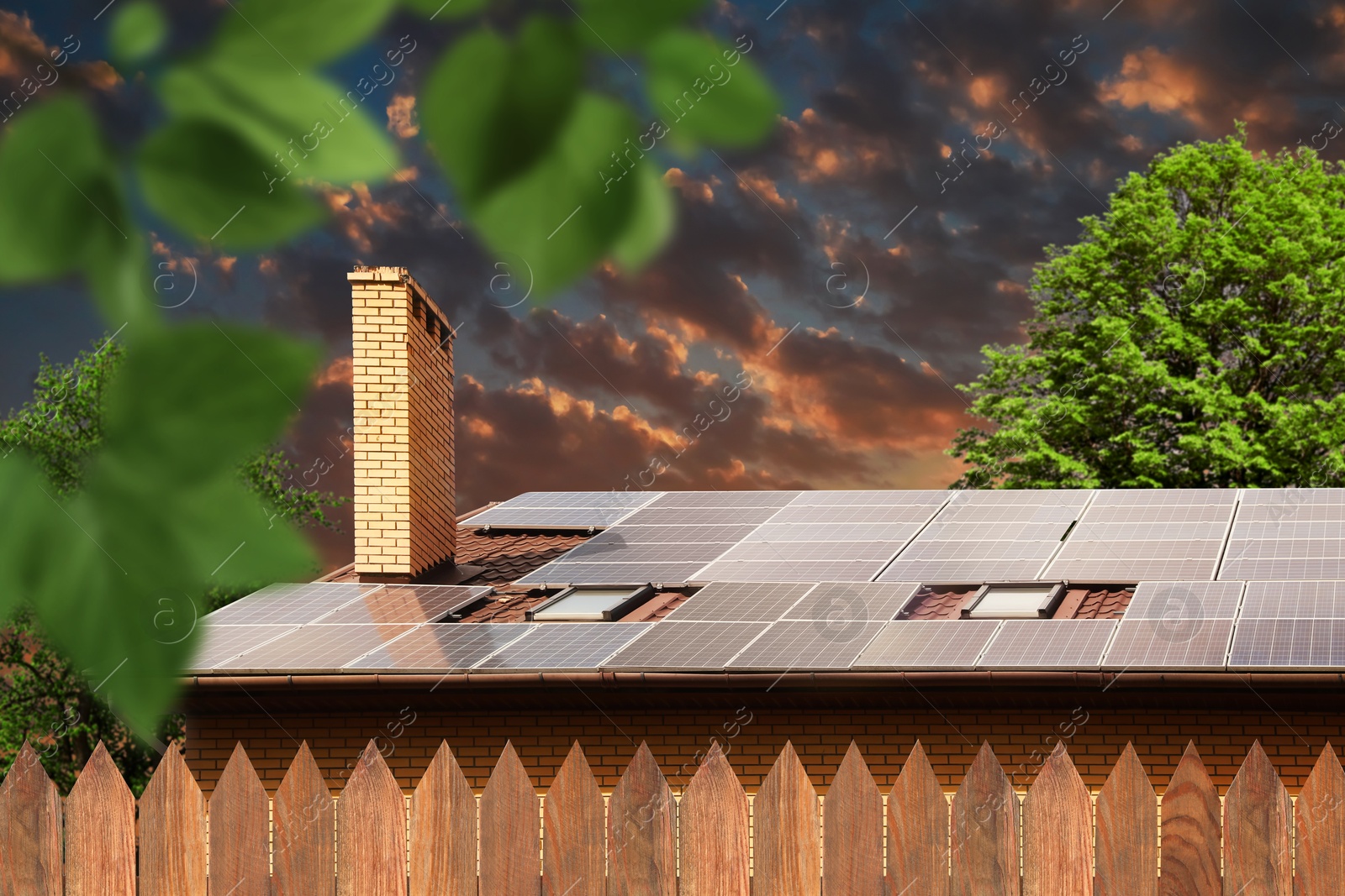 Image of Green energy. House with solar panels on roof at sunset