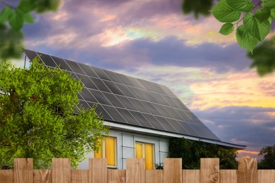 Image of Green energy. House with solar panels on roof at sunset