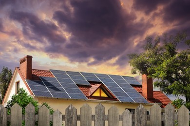 Image of Green energy. House with solar panels on roof at sunset