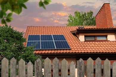 Image of Green energy. House with solar panels on roof at sunset