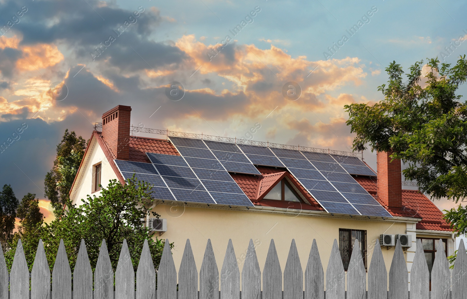 Image of Green energy. House with solar panels on roof at sunset