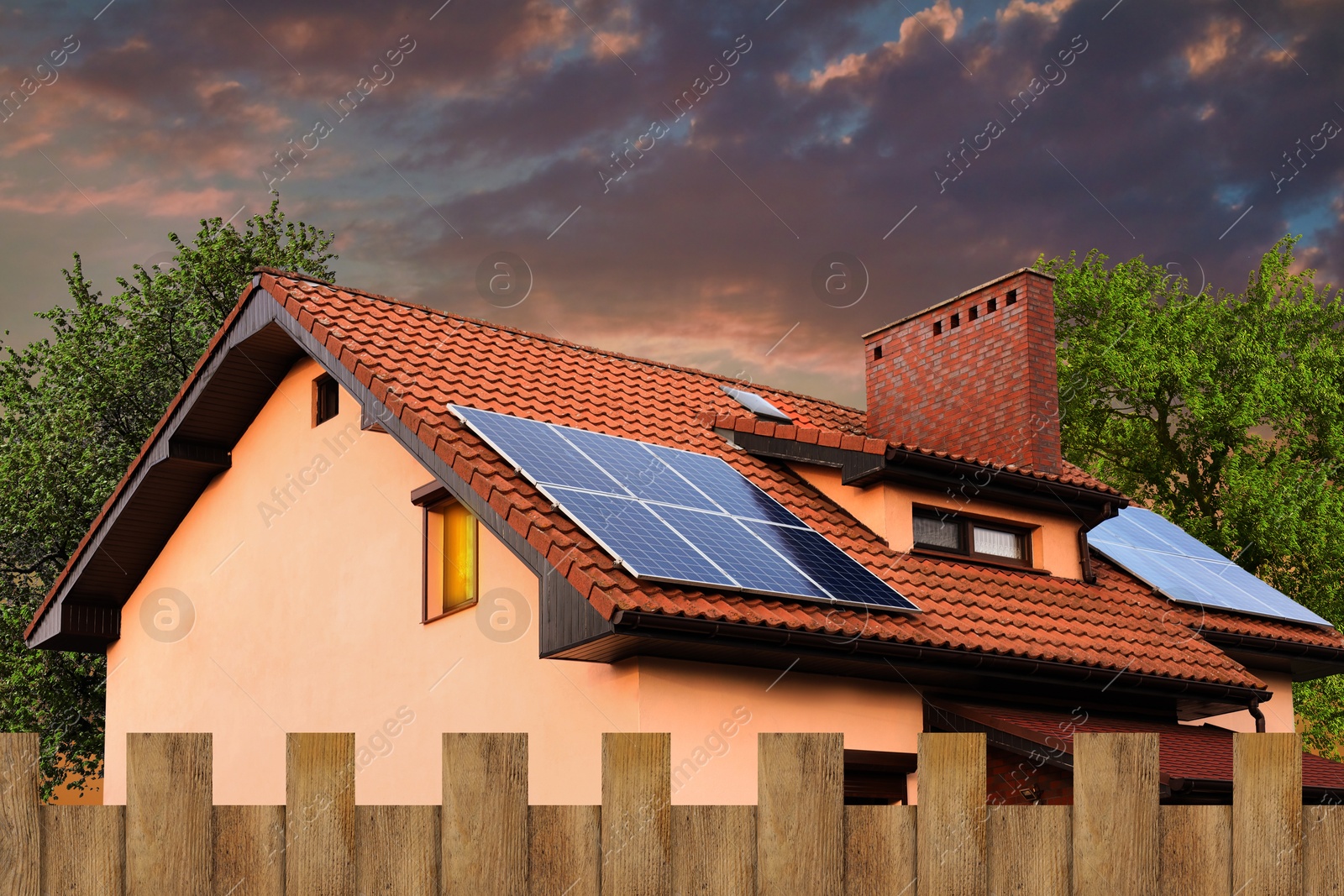 Image of Green energy. House with solar panels on roof at sunset