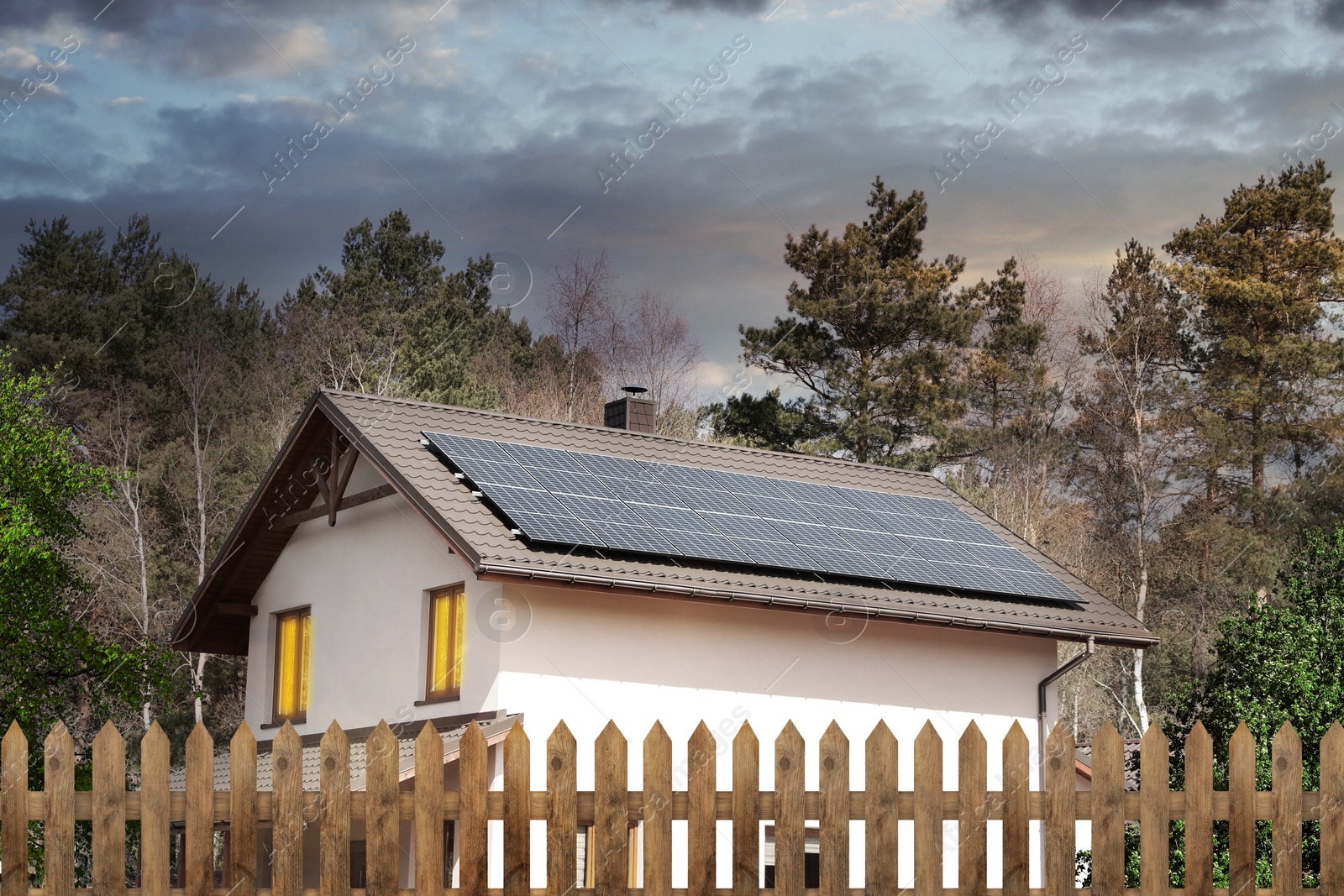 Image of Green energy. House with solar panels on roof at sunset