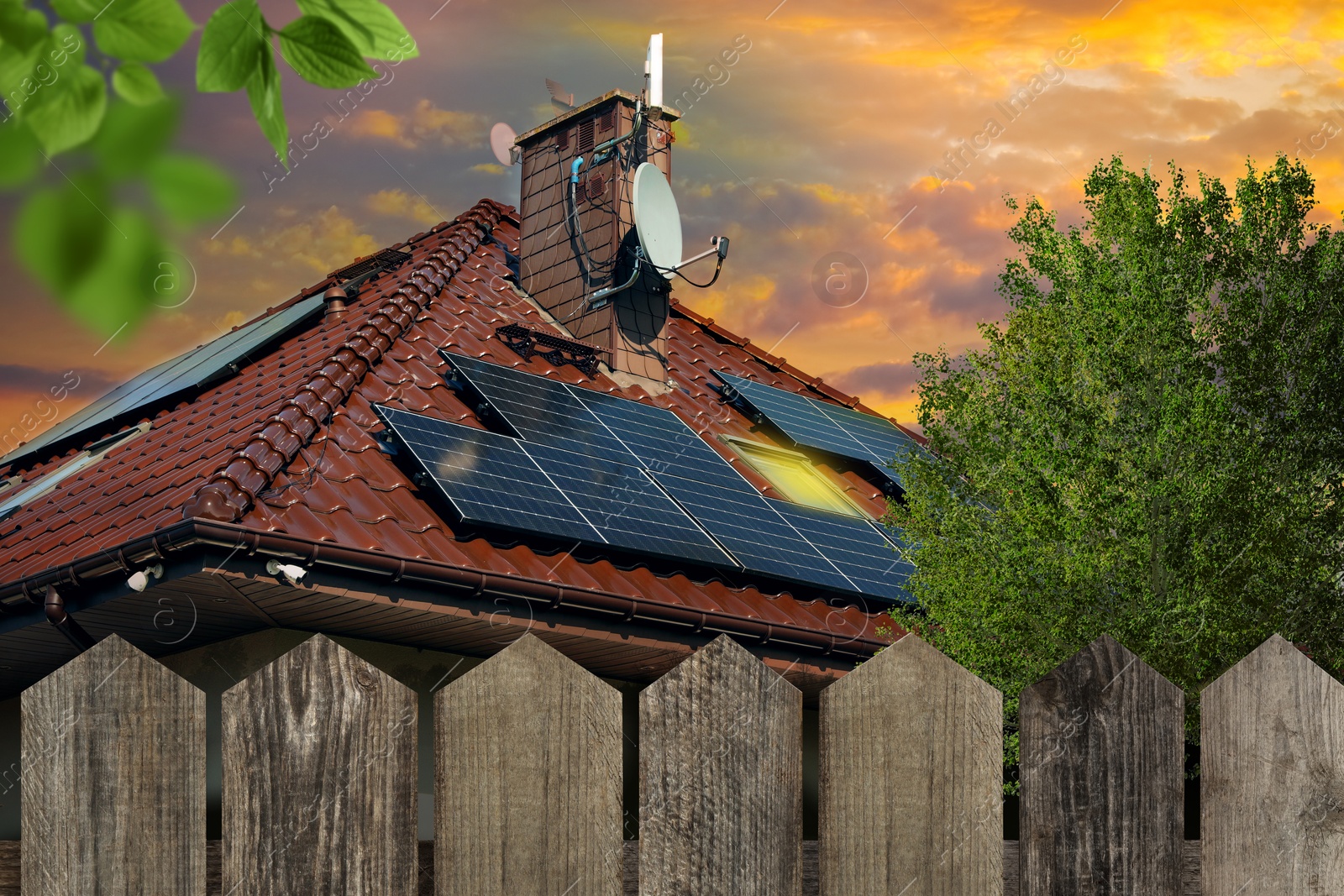 Image of Green energy. House with solar panels on roof at sunset