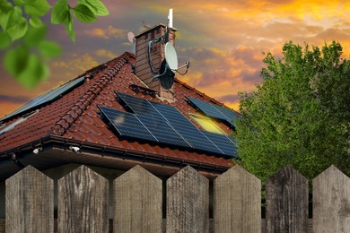 Image of Green energy. House with solar panels on roof at sunset