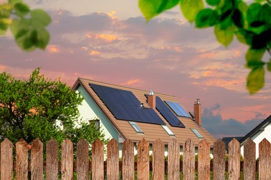 Image of Green energy. House with solar panels on roof at sunset