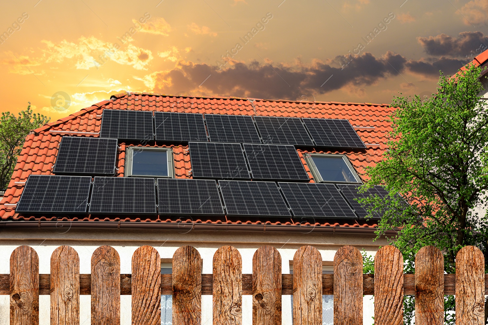 Image of Green energy. House with solar panels on roof at sunset