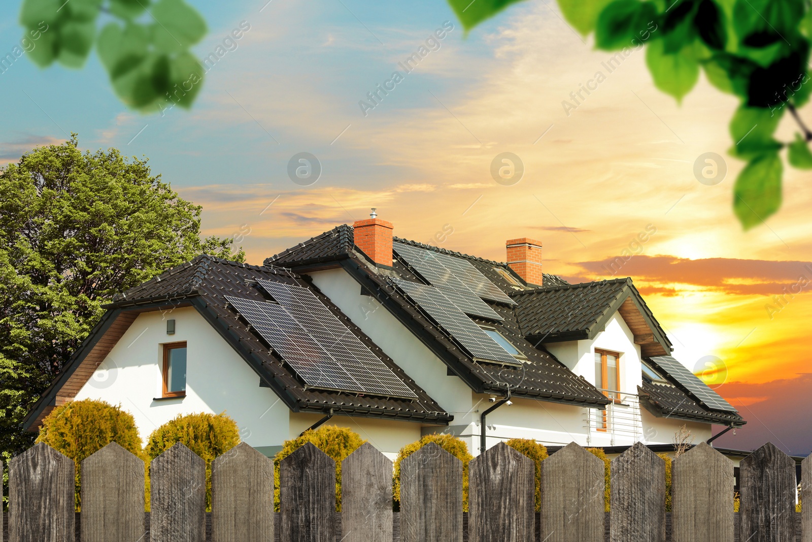 Image of Green energy. House with solar panels on roof at sunset