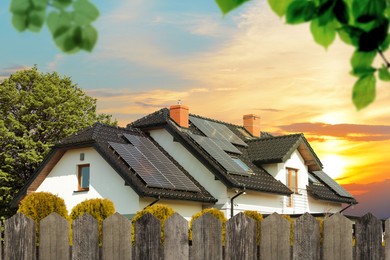 Image of Green energy. House with solar panels on roof at sunset