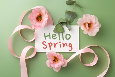 Image of Hello Spring card, beautiful flowers, ribbon and eucalyptus branch on paste green background, flat lay