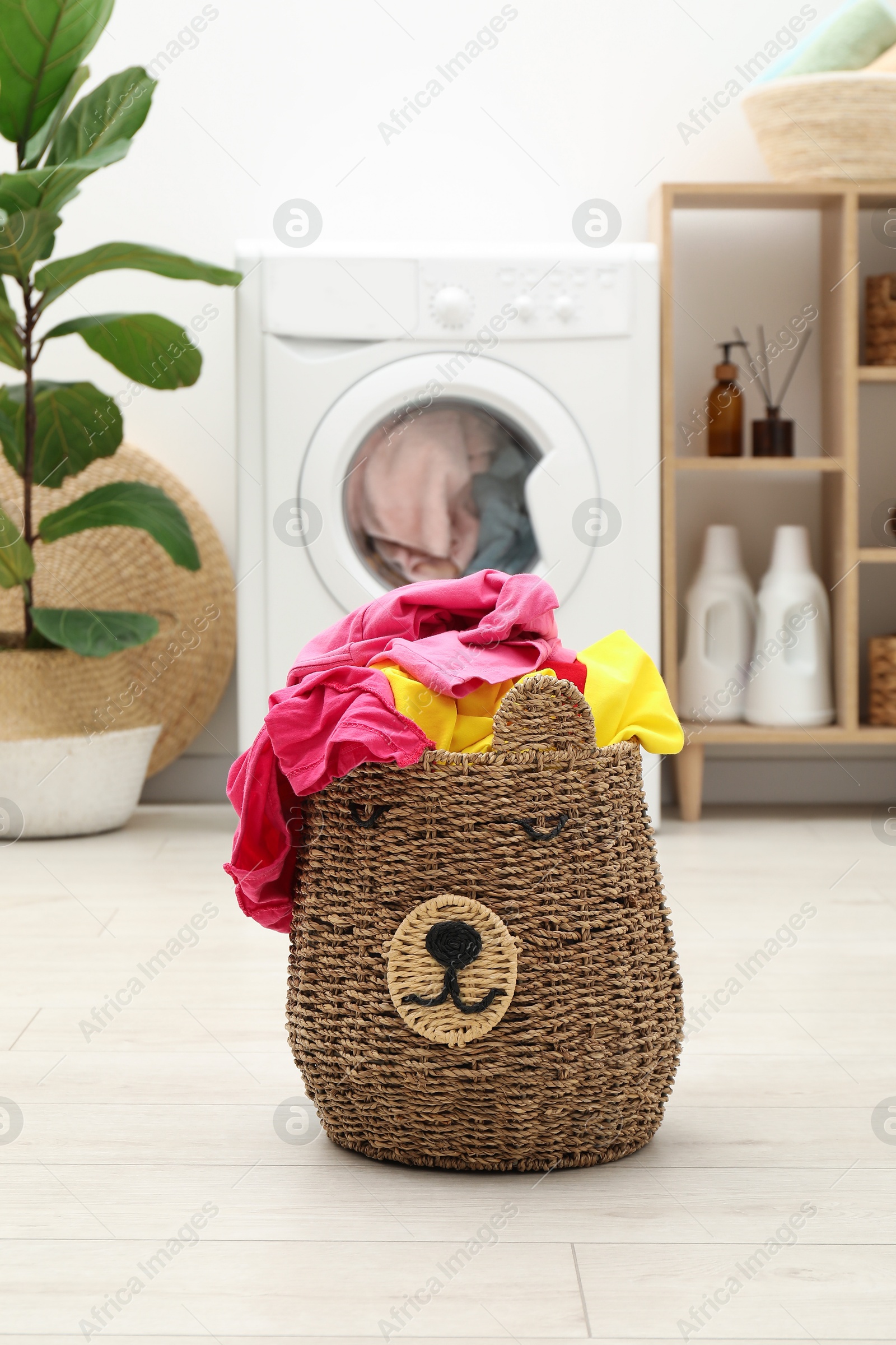 Photo of Wicker basket full of laundry in bathroom