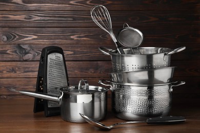 Photo of Dishware and cooking utensils on wooden table