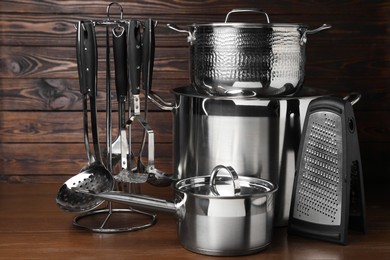 Photo of Dishware and cooking utensils on wooden table