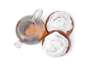 Photo of Tasty cinnamon rolls with cream and tea isolated on white, top view