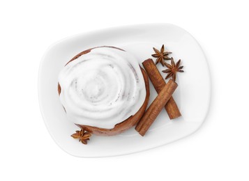 Photo of Tasty cinnamon roll with cream and spices isolated on white, top view