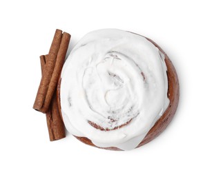 Photo of Tasty cinnamon roll with cream and sticks isolated on white, top view