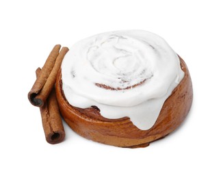 Photo of Tasty cinnamon roll with cream and sticks isolated on white