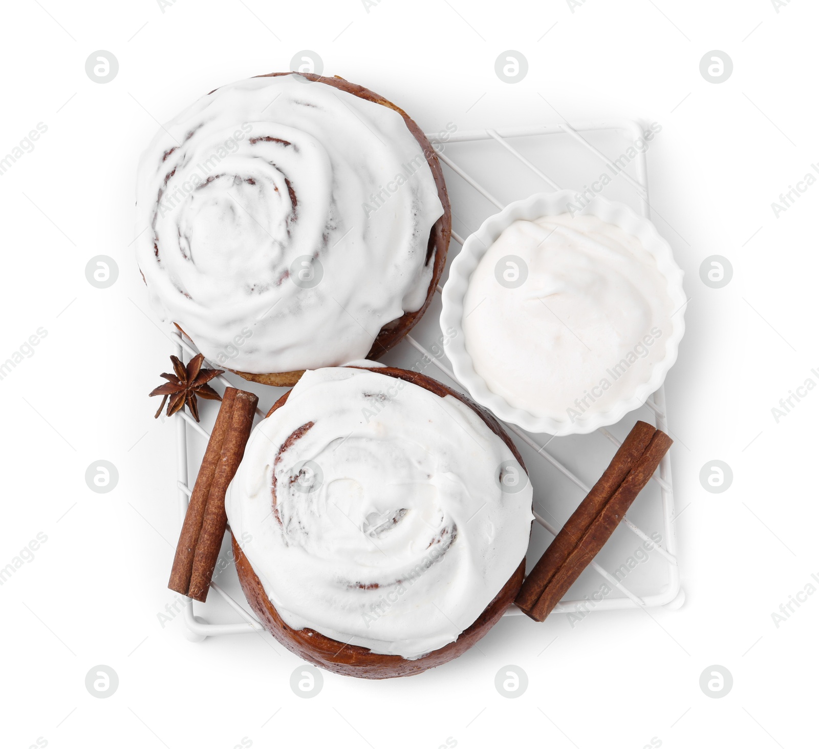 Photo of Tasty cinnamon rolls with cream and spices isolated on white, top view