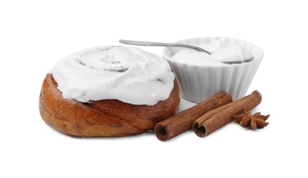 Photo of Tasty cinnamon roll with cream and spices isolated on white