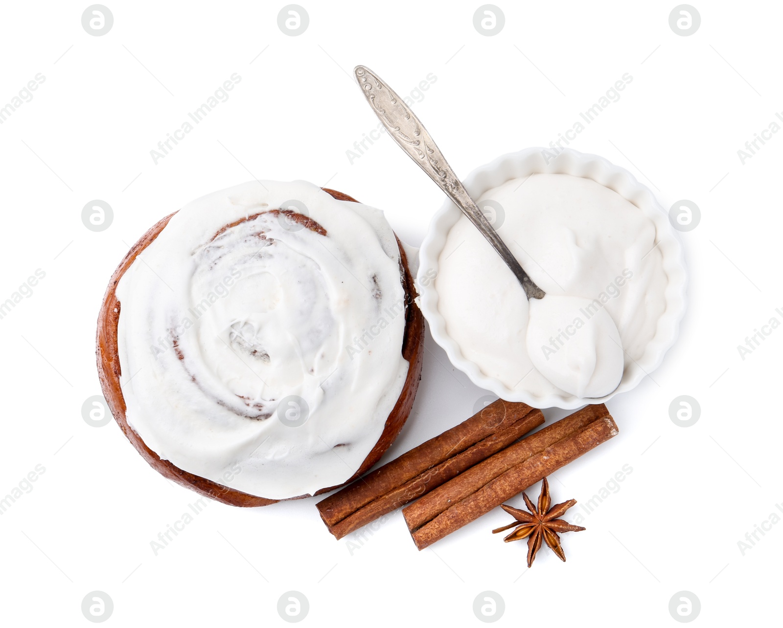 Photo of Tasty cinnamon roll with cream and spices isolated on white, top view