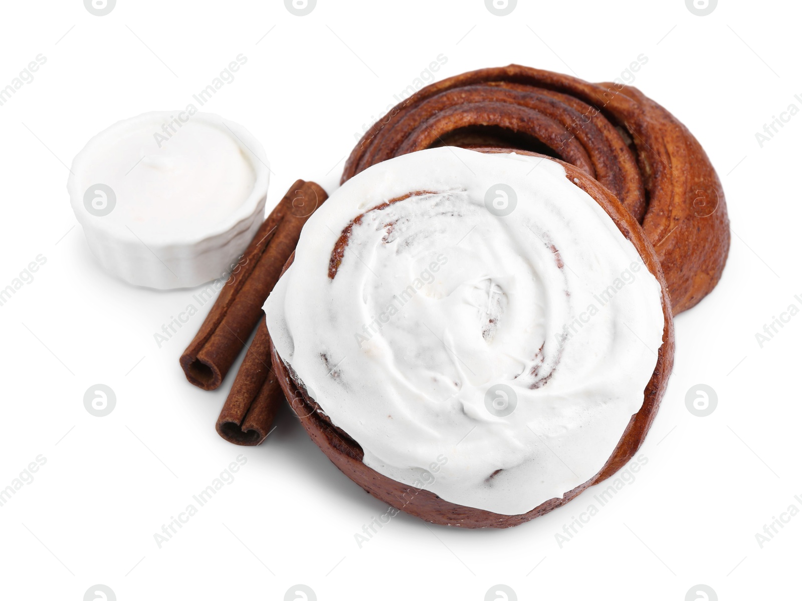 Photo of Tasty cinnamon rolls with cream and sticks isolated on white