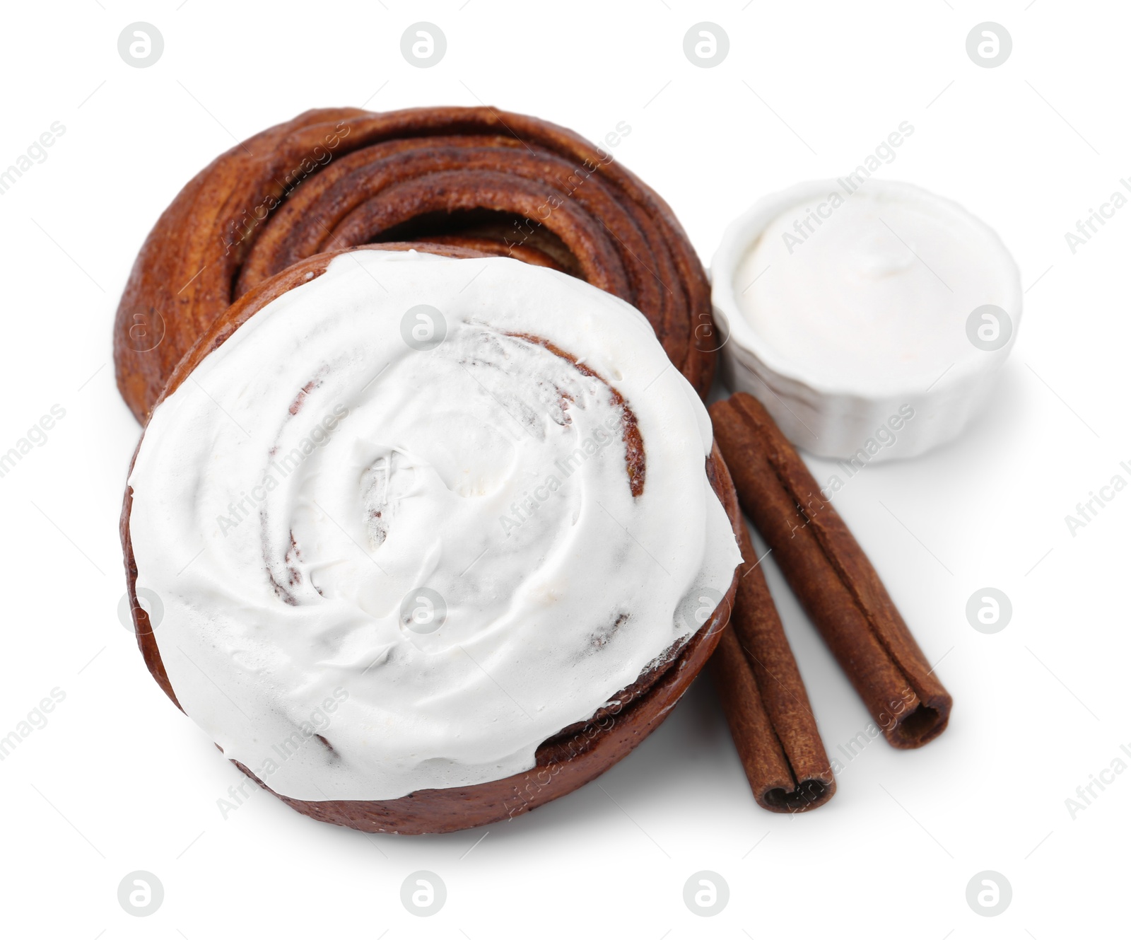 Photo of Tasty cinnamon rolls with cream and sticks isolated on white